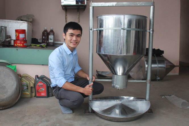 Minh Công bên chiếc máng ăn tự động cho heo do mình sáng chế - Ảnh: HUỲNH HÀ