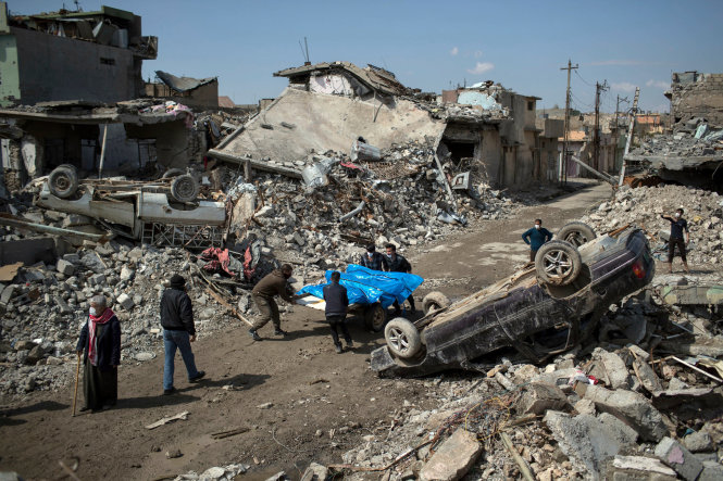 Người dân ở phía tây thành phố Mosul đang đưa thi thể những người bị sát hại trong cuộc chiến giữa lực lượng an ninh Iraq và IS - Ảnh: AP
