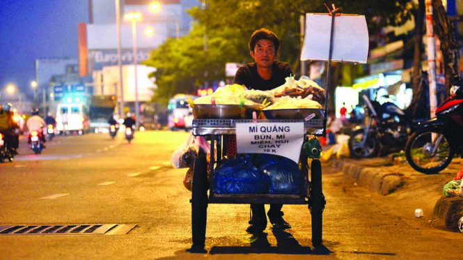 5h sáng, anh Lê Long Anh đẩy hàng đi trước, vợ ở nhà lo cho các con đi học rồi ra sau - Ảnh: Duyên Phan