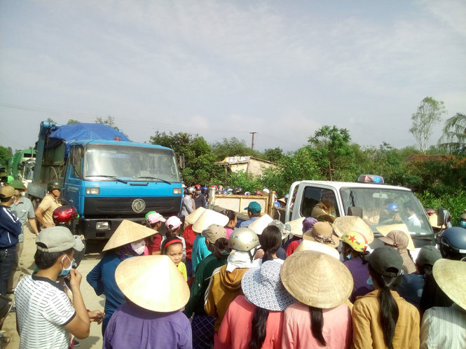 Lực lượng chức năng tiến hành bảo vệ cho xe vào khu xử lý rác trước sự ngăn cản của người dân chiều 30-3 - Ảnh: XUÂN ĐÀO