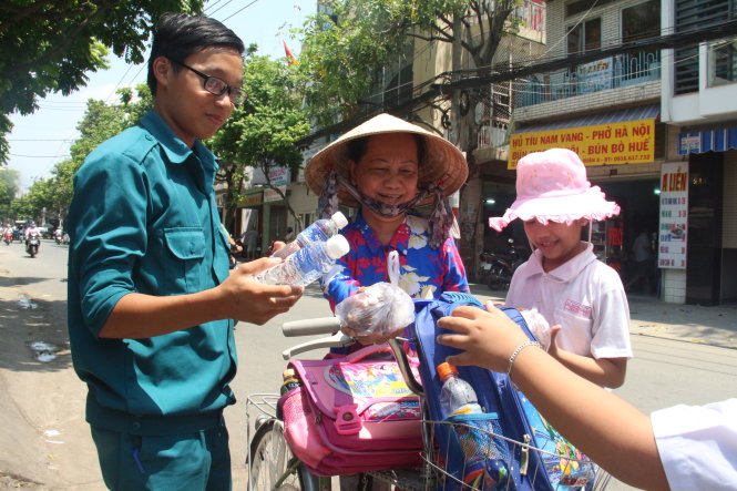 Chiến sĩ dân quân tự vệ phường 3, quận 8 phát suất ăn miễn phí cho người dân - Ảnh: Mi.Phượng