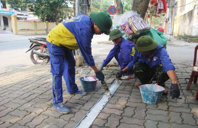 Nhân viên Công ty cổ phần quản lý và phát triển hạ tầng đô thị TP Vinh tiến hành kẻ vạch dành cho người đi bộ - Ảnh: DOÃN HÒA