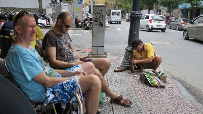 Du khách nước ngoài thích thú ngồi vỉa hè, uống cà phê, uống trà ngắm phố phường trung tâm Sài Gòn - Ảnh: T.T.D.