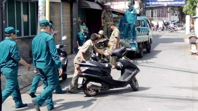 Cơ quan chức năng tạm giữ xe của người dân tại khu chung cư 830, Sư Vạn Hạnh , Q.10 - Ảnh: Lê Phan