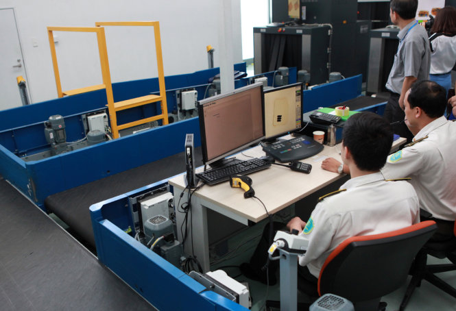 Soi chiếu an ninh hành lý khách đi máy bay tại Nội Bài - Ảnh: TUẤN PHÙNG