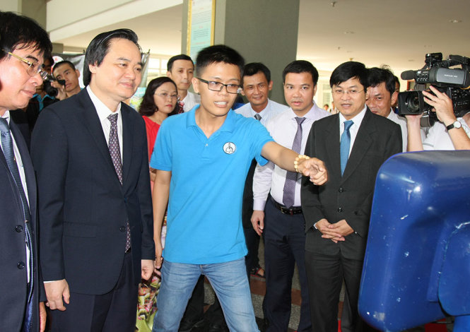 Sinh viên Trường ĐH Sư phạm kỹ thuật TP.HCM giới thiệu các sản phẩm công nghệ robot tiếp tân với Bộ trưởng Bộ GD-ĐT Phùng Xuân Nhạ - Ảnh: Trần Huỳnh