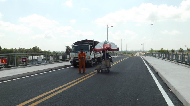 Các công nhân đang sơn đường và làm vệ sinh mặt cầu trước ngày thong xe