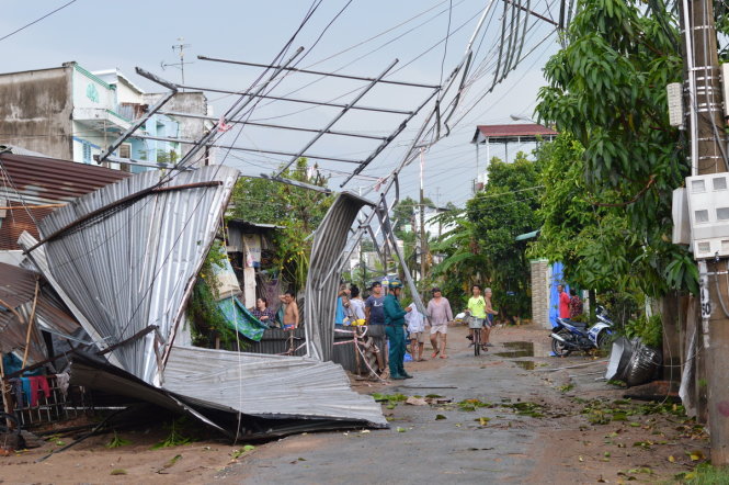 Nhà dân bị giông lốc cuốn phăng vướng vào đường điện trung thế - Ảnh: NGỌC TÀI