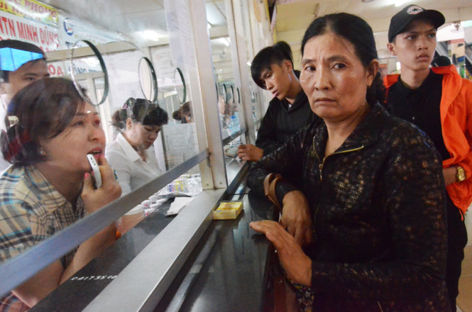 Một hành khách mua không có vé về quê Phú Yên hôm nay. Nghe giá ghế xúp đến 250-280 ngàn/vé, bà thương lượng với nhà xe để xin giảm giá vé. Giá giường nằm đến 350 ngàn nhưng đã hết - Ảnh: Uyên Trinh