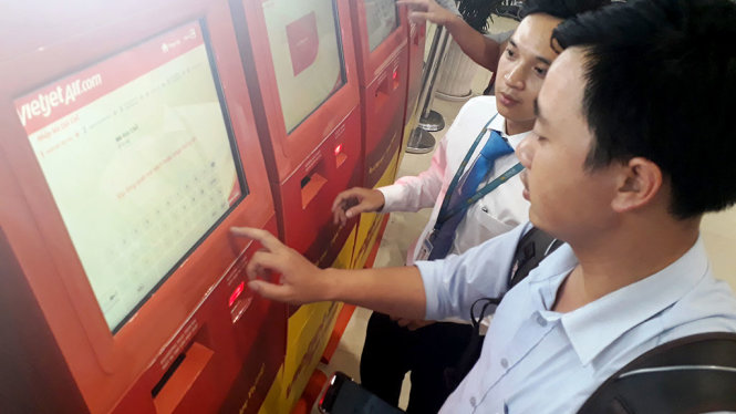 Hành khách thong thả sử dụng máy check–in để giảm thiểu thời gian xếp hàng làm thủ tục tại quầy
