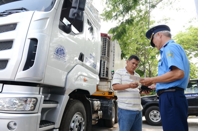 Lực lượng TTGT kiểm tra tải trọng tại trạm cân số 3 trên đường Nguyễn Văn Linh, Q.7, TP.HCM - Ảnh: Quang Định