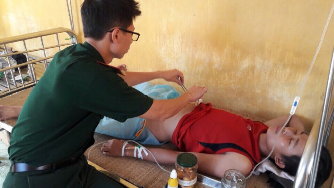 Quân y trên đảo Phan Vinh điều trị cho một ngư dân bị bệnh khi đánh cá ở ngư trường Trường Sa - Ảnh: H.L.H.