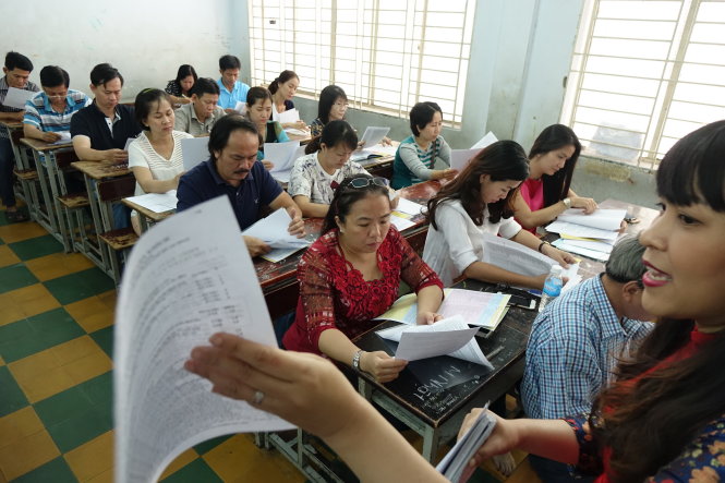 Cô Lê Thị Thùy Nhung, giáo viên chủ nhiệm lớp 9/4 Trường THCS Colette (Q.3, TP.HCM), hướng dẫn phụ huynh ghi hồ sơ đăng ký dự thi kỳ thi tuyển sinh lớp 10 năm 2017 - Ảnh: NHƯ HÙNG