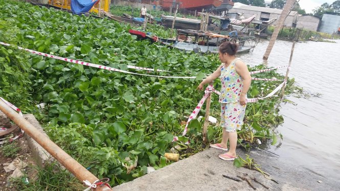 Quả bom nằm lẫn trong đám lục bình được cơ quan chức năng giăng dây cảnh báo