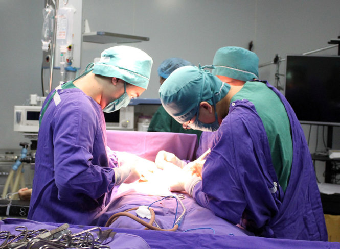 Các bác sĩ mổ lấy khối u - Ảnh: HÀ TRANG