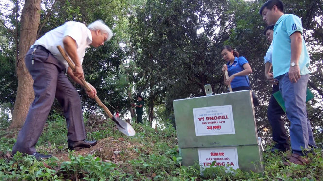 Ông Phạm Việt Dũng, giám đốc Sở Văn hóa - thể thao và du lịch Điện Biên, khẽ khàng lấy chút lớp đất trên đồi A1 - Ảnh: NAM TRẦN