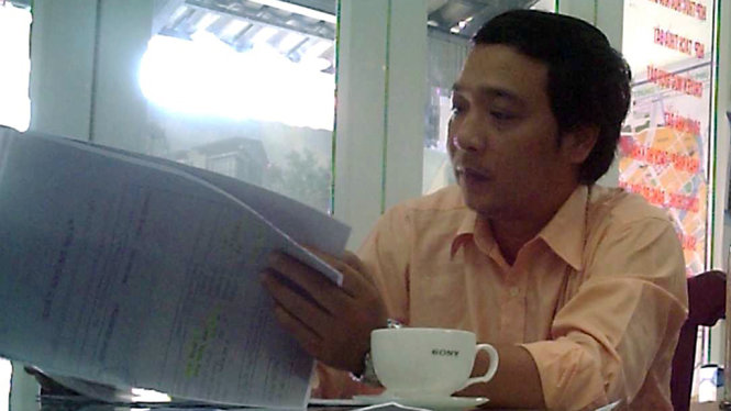 Ông Lê Văn Tấn, cán bộ chi nhánh Văn phòng đăng ký đất đai Q.7, xuất hiện bàn việc