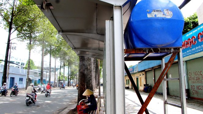 Người chờ xe buýt tại nhà chờ được gắn máy phun sương - Ảnh: Thu Trang