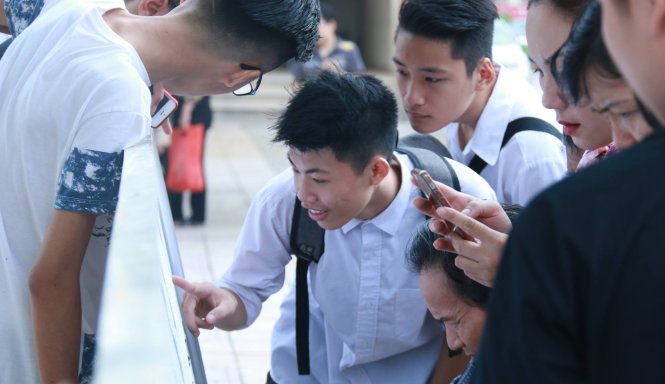 Thí sinh xem danh sách phòng thi - Ảnh: Th.Hùng