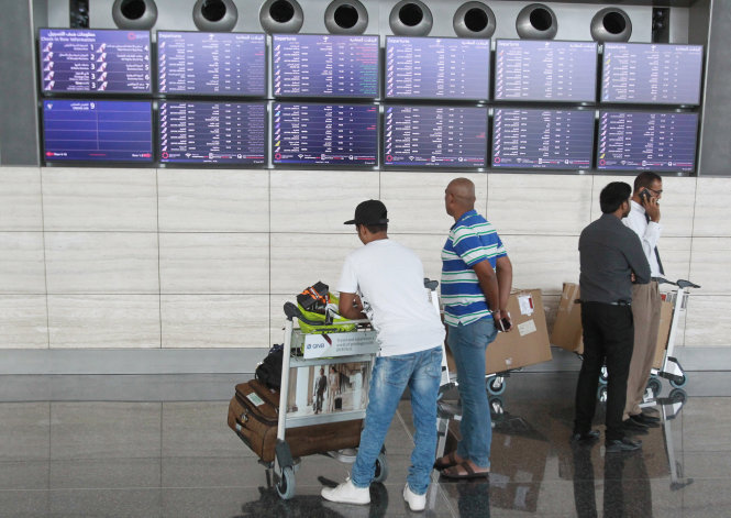 Hành khách kiểm tra thông tin tại sân bay Hamad ở Doha, Qatar. Căng thẳng đã khiến nhiều gia đình trong khu vực bị ly tán và các kết nối thương mại bị cắt đứt. - Ảnh: Reuters