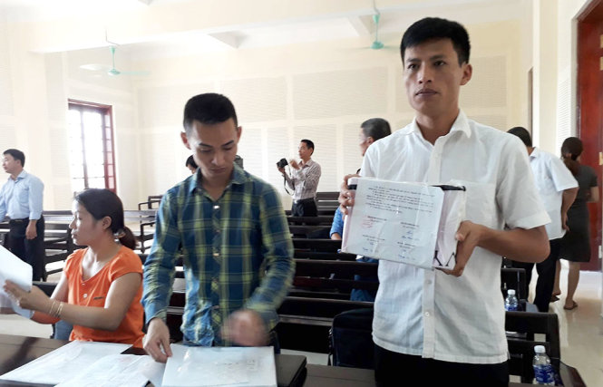 Ông Trần Tử Trường - giám đốc doanh nghiệp tư nhân Trường Sơn và số hóa đơn đang bị niêm phong - Ảnh: TRUNG THÀNH