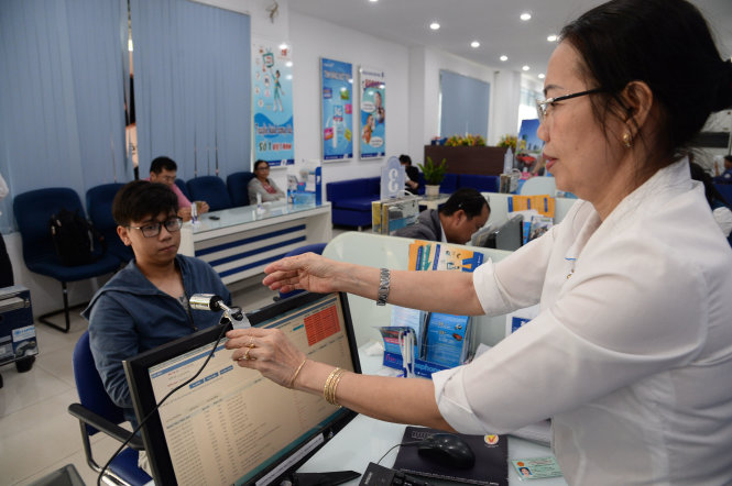 Chụp ảnh chân dung thuê bao hòa mạng mới tại một cửa hàng của Vinaphone. - Ảnh: Tự Trung