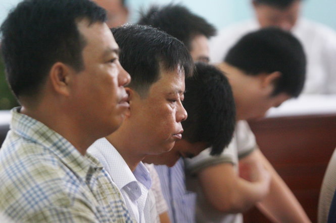 Các bị cáo nguyên là cán bộ thanh tra giao thông cúi mặt nghe chủ tọa phiên tòa phân tích về hành vi của mình - Ảnh: Chí Quốc