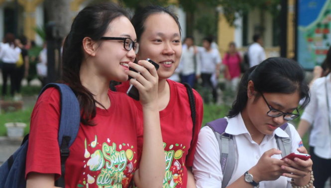 Các thí sinh tươi cười chuyện trò với nhau sau khi kết thúc môn thi tiếng Anh tại điểm thi Trường THPT Chu Văn An - Ảnh: HOÀI NAM