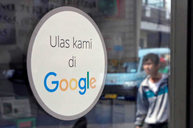 Một sticker với nội dung “đánh giá chúng tôi trên Google” được dán tại một cửa hàng máy tính ở Jakarta, Indonesia - Ảnh: Reuters