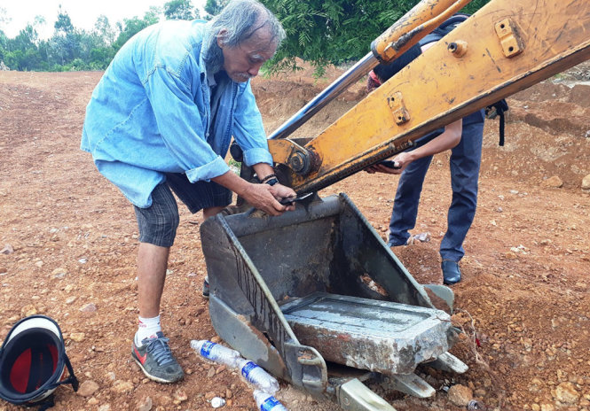 Tấm bia đá bị vùi lấp làm bãi đỗ xe được tìm thấy hôm 24-6 - Ảnh: NHẬT LINH