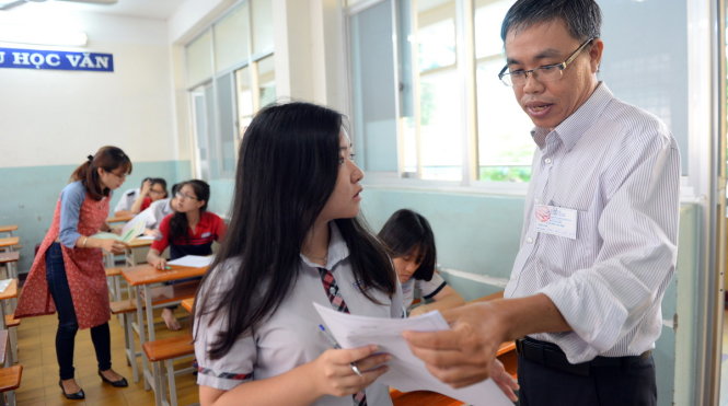 Giám thị hướng dẫn thí sinh làm thủ tục tại điểm thi Trường THPT Erst Thalmann, Q.1, TP.HCM - Ảnh: Hữu Khoa