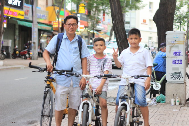 Ba cha con anh Nguyễn Phi Bằng cùng đi xe đạp để rèn kỹ năng xử lý tình huống trên đường phố - Ảnh: DOÃN ĐÀO
