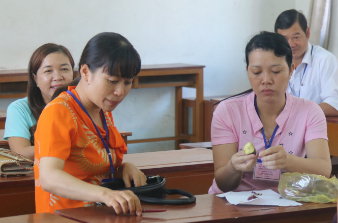 Cán bộ chấm thi tại một điểm chấm thi ở TP Rạch Giá, tỉnh Kiên Giang tranh thủ ăn sáng với khoai lang, trước khi nhận bài thi để chấm - Ảnh: K.Nam