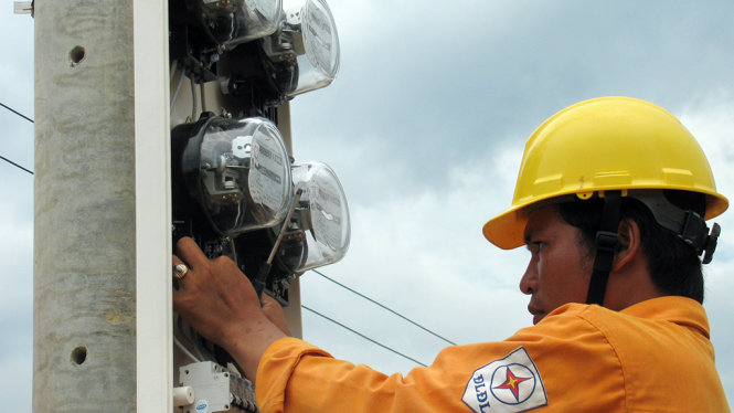 Chi phí đầu vào tăng, nhu cầu đầu tư lớn đang tạo áp lực lên giá điện. Trong ảnh: nhân viên EVN lắp điện kế để bán điện cho người dân - Ảnh: V.Hà