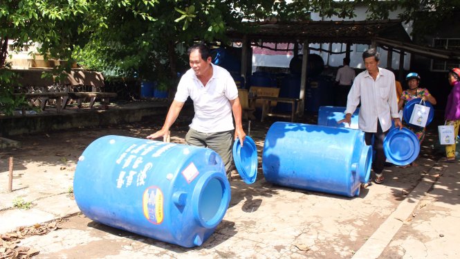 Niềm vui của người dân khi nhận bồn chứa nước - Ảnh: K.T