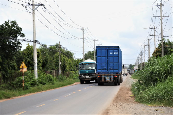 Tỉnh lộ 8 chật hẹp nhưng 10 năm qua dự án nâng cấp, mở rộng đường này vẫn triển khai ì ạch, phần lớn chưa được tiến hành thi công - Ảnh: T.ĐỨC