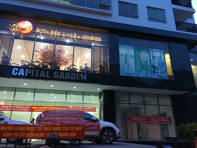 Cư dân tụ tập căng băng rôn phản đối chủ đầu tư cắt điện, nước - Ảnh: CTV