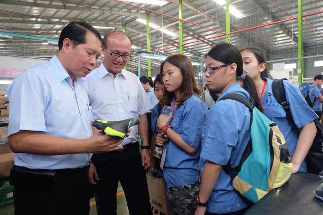 TS Lâm Đằng Giao (thứ hai từ trái qua) và lãnh đạo tập đoàn DDK đưa các em vào xưởng - Ảnh: VŨ THỦY