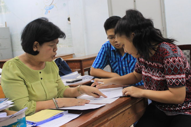 Cán bộ Trường THPT Marie Curie (Q.3, TP.HCM) hướng dẫn thí sinh điều chỉnh nguyện vọng - Ảnh: PHƯƠNG NGUYỄN