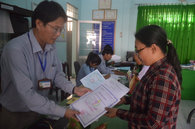 Đại diện UBND phường Mỹ Phú (Cao Lãnh, Đồng Tháp) trao thư chia buồn cho bà Huỳnh Thị Thu Hồng - Ảnh: NGỌC TÀI