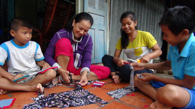 Mấy chị em Dung phụ bà Oanh may đồ nhấc nồi - Ảnh: M.TÂM