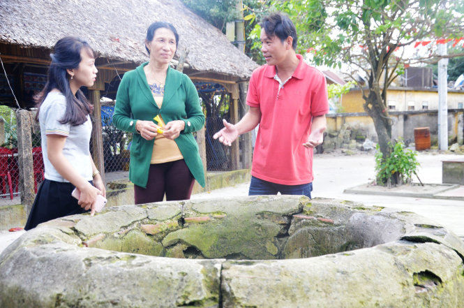 Sinh “thổ địa” dẫn khách tham quan giếng cổ 400 năm tuổi - Ảnh: THANH BA