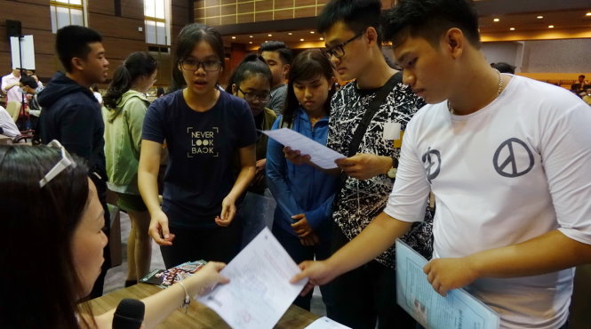 Thí sinh, phụ huynh nhận giấy báo trúng tuyển tại Trường ĐH Kinh tế TP.HCM ngày 2-8 - Ảnh: NHƯ HÙNG