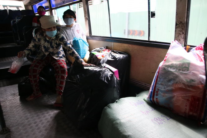 Nhiều bao hàng to vẫn được đưa lên xe buýt - Ảnh: Hữu Khoa