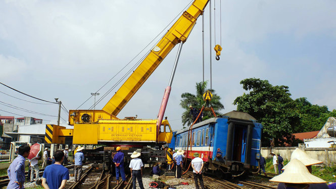 ngành đường sắt đang khắc phục sự cố tàu SP2 trật bánh 2 toa tại ga Yên Viên - Ảnh: SĨ THƯỜNG
