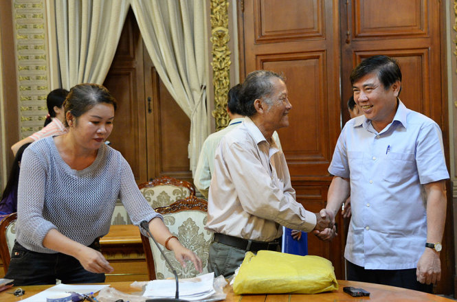 Chủ tịch UBND TP.HCM Nguyễn Thành Phong trao đổi với ông Nguyễn Thanh Giảng xã Vĩnh Lộc A, huyện Bình Chánh đã 20 năm đi khiếu nại tranh chấp về đường hẻm bị xây nhà không có lối đi - Ảnh: TỰ TRUNG