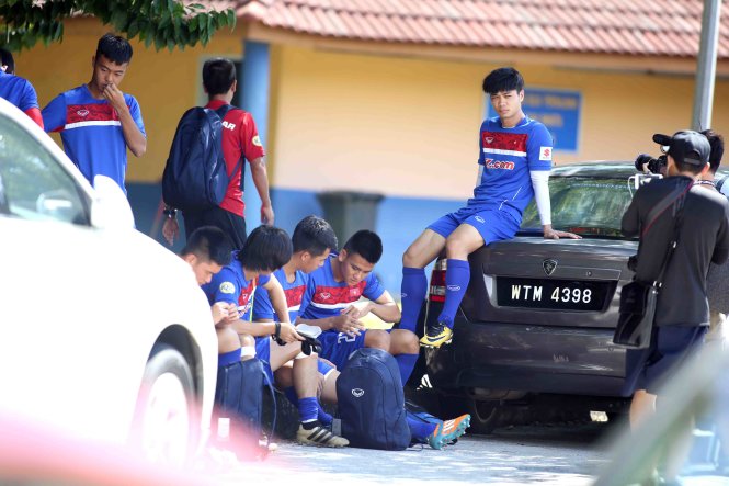 Cầu thủ U-22 VN ngồi chờ mở cửa sân tập. Ảnh: N.K