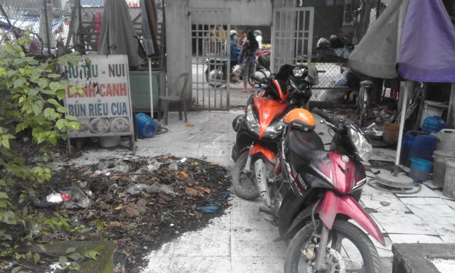 Bên trong khu vực bia tưởng niệm liệt sĩ chứa đầy rác, phế liệu và trở thành nơi để xe máy - Ảnh: LĨNH HỒNG