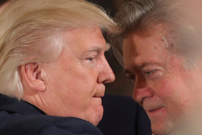 Ông Trump nói chuyện với ông Bannon (phải) trong một sự kiện tại Nhà Trắng - Ảnh: Reuters