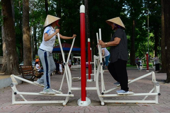 Người dân tranh thủ tập thể dục ở các máy tập nơi công cộng - Ảnh: QUANG ĐỊNH
